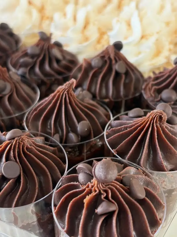 Vasitos de postre de chocolate con crema en espiral y chips de chocolate